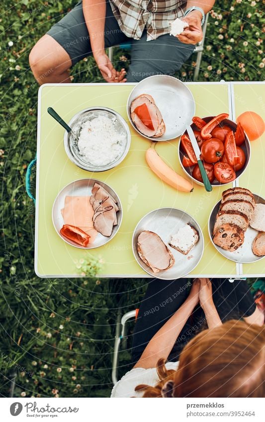 Family having breakfast outdoors on camping during summer vacation authentic real banana cooked meat slow living outdoor table setting outdoor activities