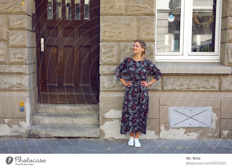 Young woman in summer dress stands in front of a house facade Woman Feminine Entrance Fashion Stand Self-confident Cool (slang) Serene portrait Front view