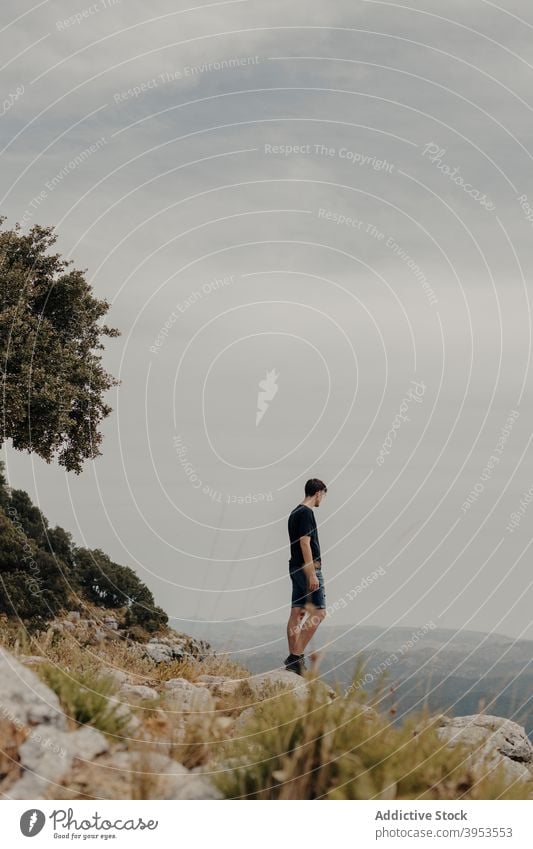 Traveler contemplating nature from mountain traveler hiker slope contemplate observe explore man rocky landscape alone lonely male wanderlust adventure highland