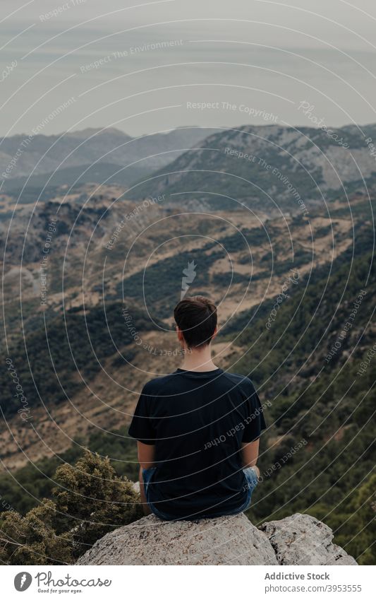 Traveler contemplating nature from mountain traveler hiker slope contemplate observe explore man rocky landscape alone lonely male wanderlust adventure highland