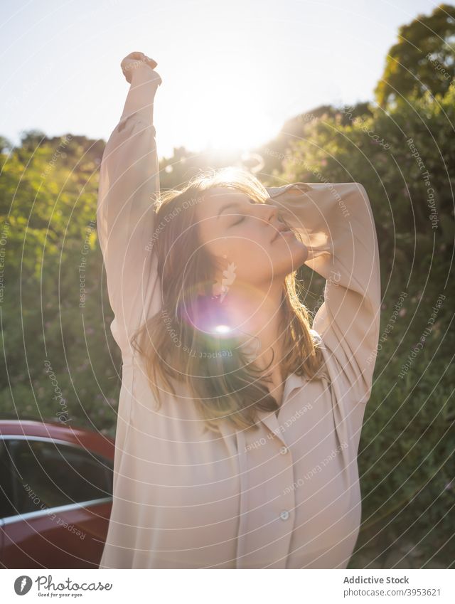 Carefree woman in park in summer carefree nature tranquil tender sunny garden calm female peaceful rest daytime green relax young serene harmony stand enjoy