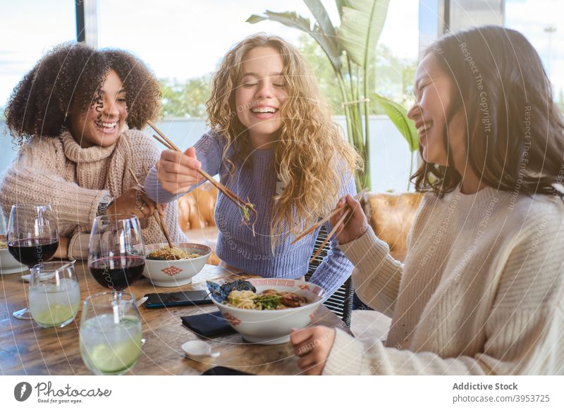 Happy girlfriends enjoying oriental dinner together women eat ramen having fun cheerful group asian food young female multiracial multiethnic diverse restaurant