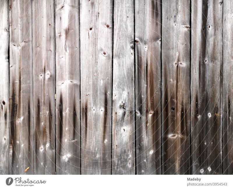 Beautiful brown old wood with grain and knotholes of a hut on a farm in Upper Bavaria Wood Facade board Rough Old Wood grain Knothole Craft (trade) Tradition