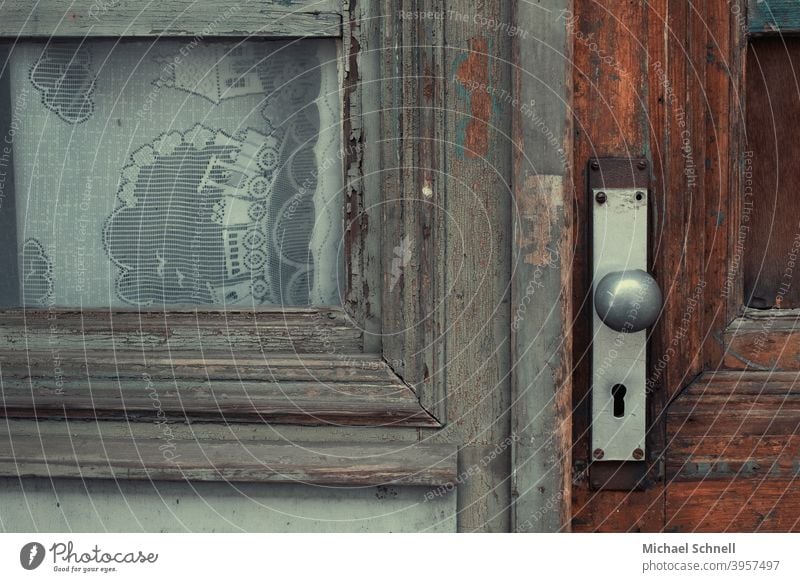 Old wooden door and window with children's curtains Wooden door Colour photo Deserted Exterior shot Detail Lock Front door Door handle Closed Entrance Curtain