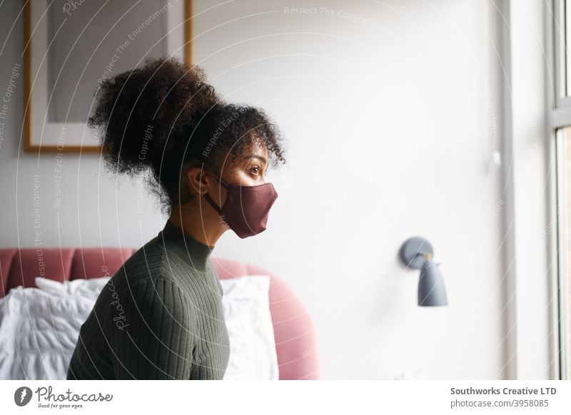 Woman wearing face mask in bedroom before leaving home during health pandemic woman house at home face covering ppe putting on social distancing women female