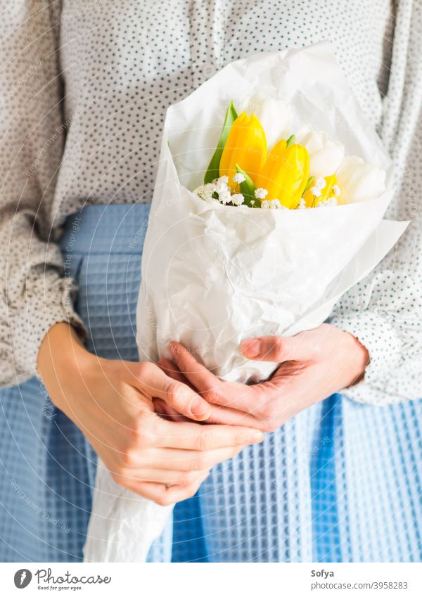 Woman holding bouquet of tulips. Woman's day flower bunch mother woman give spring easter hands floral white yellow lady march gift invitation greeting card