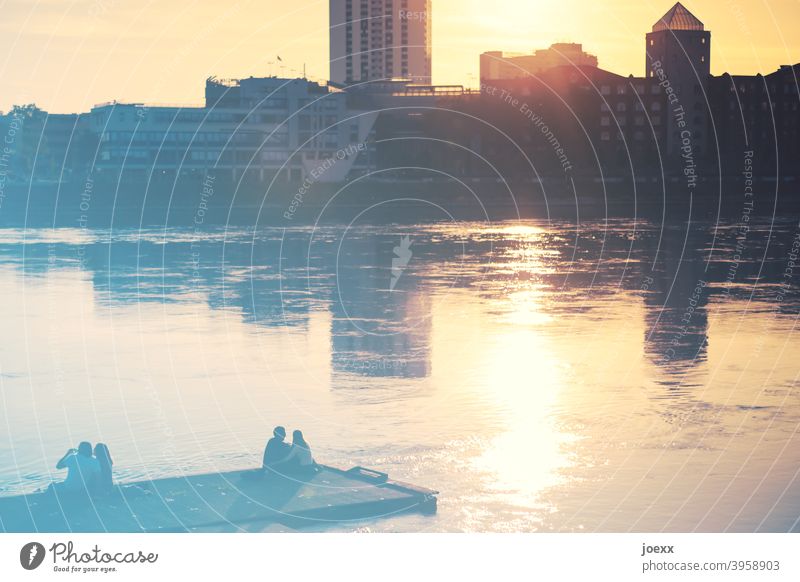 Two couples sit relaxing by the water enjoying the sunset on the skyline. BEFORE Corona people Couples Footbridge Water River bank at the same time Sunset