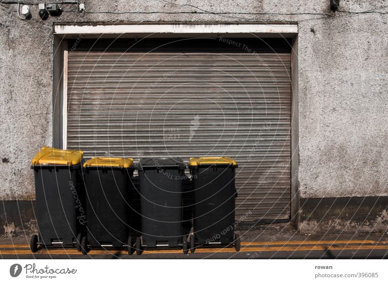 I'm going to the trash can. Facade Dirty Trash Trash container Refuse disposal Yellow Garage Garage door Shabby Closed Row Recycling Colour photo Subdued colour