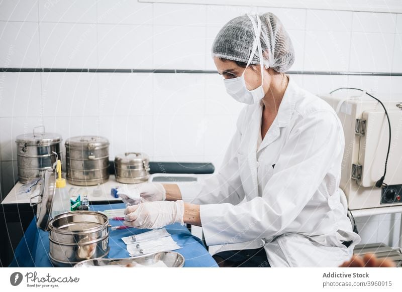 Protected doctor preparing gauze and injections on a table in an hospital CrotoChic assistance assistant care caucasian clinic emergency equipment face gloves