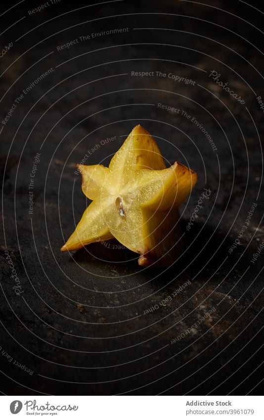 Side view of a carambola cut in half on rustic wooden background fruit food isolated yellow healthy slice fresh ripe diet orange tropical juicy organic star raw