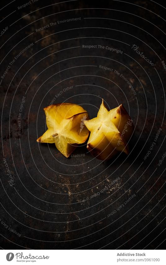 Top view of a carambola cut in half on rustic wooden background fruit food isolated yellow healthy slice fresh ripe diet orange tropical juicy organic star raw