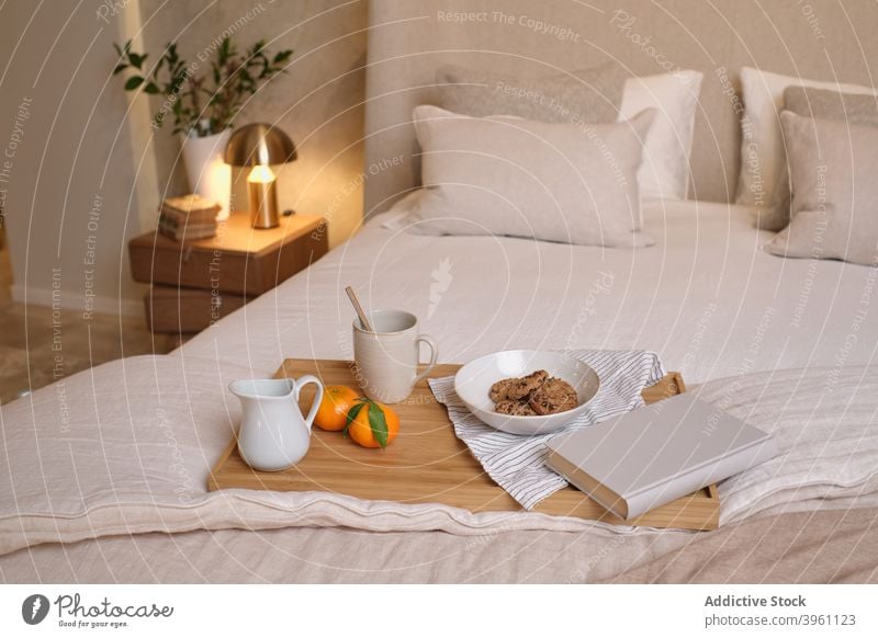 Breakfast on bed in cozy bedroom breakfast food tray drink morning comfort home book apartment wooden modern coffee beverage blanket novel tasty literature