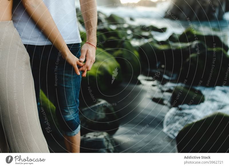 Romantic couple holding hands on rocky seashore romantic love coast together fondness close tenerife island canary beach spain relationship affection lifestyle