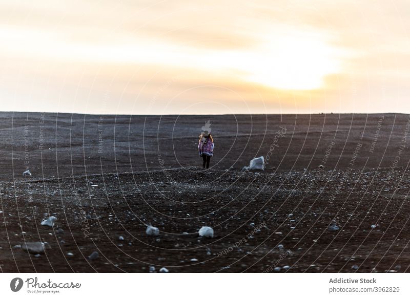 Traveling woman in field in winter sunset enjoy admire traveler scenery carefree tourist female iceland scenic sky idyllic snow sundown evening dusk tourism