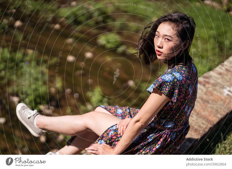 Ethnic woman sitting on bridge in summer forest vacation aged landmark female ethnic asian daping red bridge taiwan relax brick heritage travel trip tourist