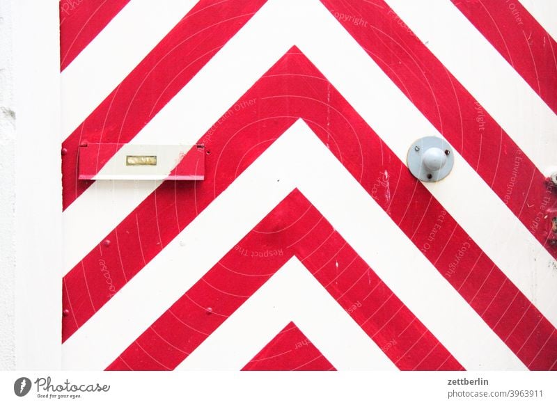 Red and white angles on a door White red and white decoration Decoration Jewellery graphic apartment door Entrance Access Mailbox mailbox flap address delivery