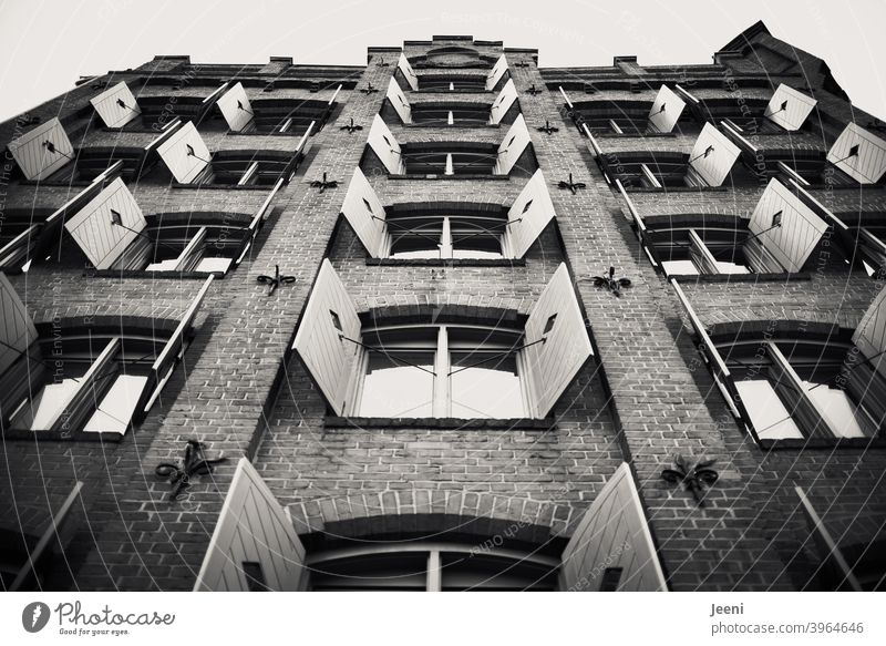 gable of an old brick house |the shutters are symmetrically opened | black and white pediment Gable end Facade Brick Brick wall Window Shutter Symmetry