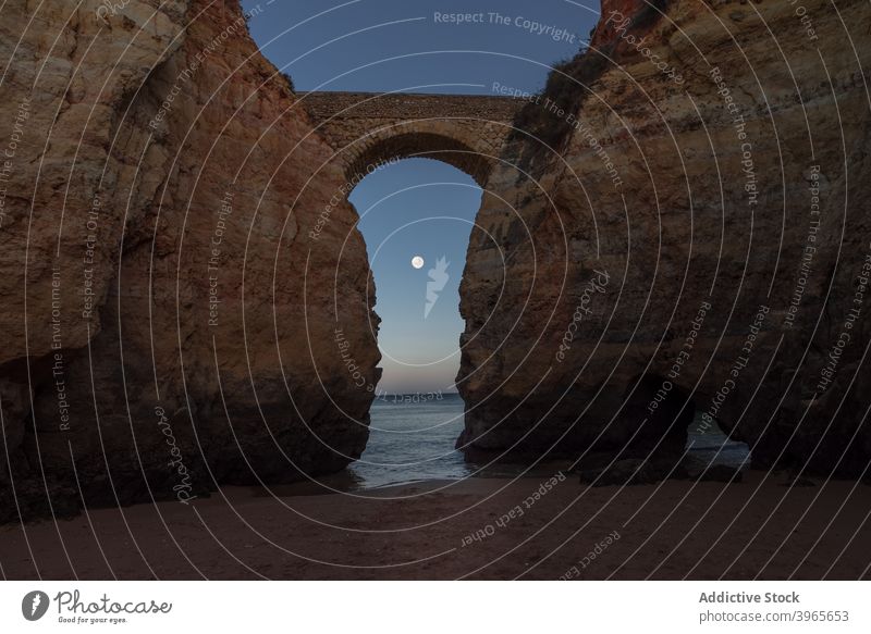 Scenic seascape with sandy shore and rocky cliffs against night sky ocean beach nature landscape evening arch coastline scenic praia de estudantes algarve