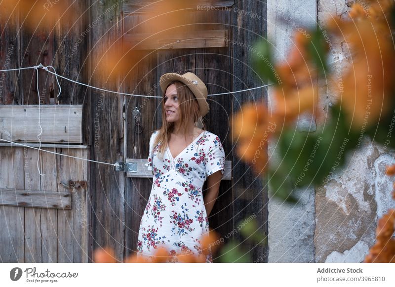 Woman standing near cozy old white house with blooming tree woman branch facade style gorgeous vacation relax rest trendy female young grace straw hat portugal