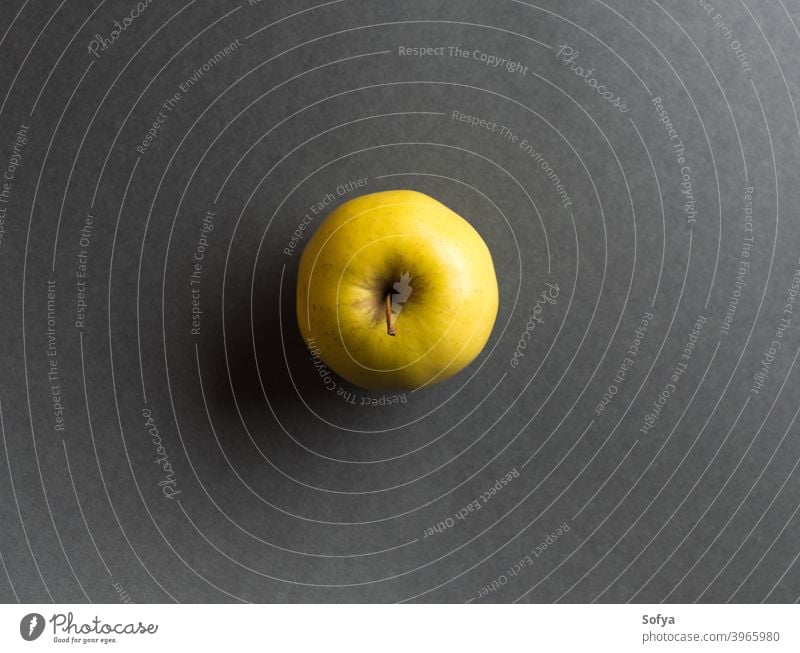 Illuminated yellow apple on dark gray background food illuminated ugly autumn winter harvest moody fruit flat lay fashion summer vitamin trendy nutrition