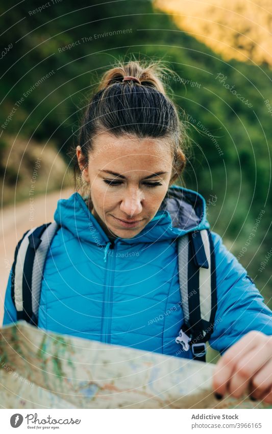 Woman reading paper map during hiking woman orientate navigate trekking location find hiker nature female adventure warm jacket warm clothes outerwear tourism