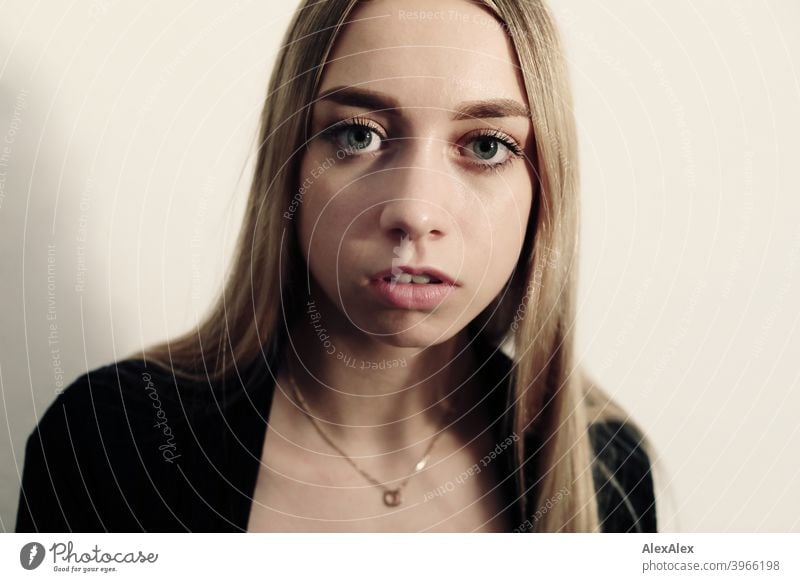 Portrait of a young long haired blonde woman in a bright room in front of a white wall Woman Girl Slim Blonde Long-haired portrait pretty Graceful Wild