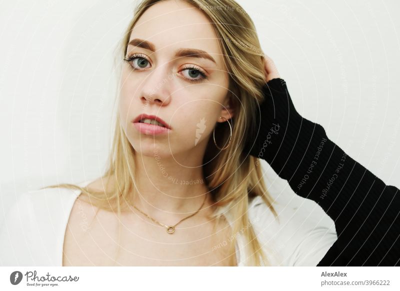 Portrait of a young long haired blonde woman in a bright room in front of a white wall Woman Girl Slim Blonde Long-haired portrait pretty Graceful Wild