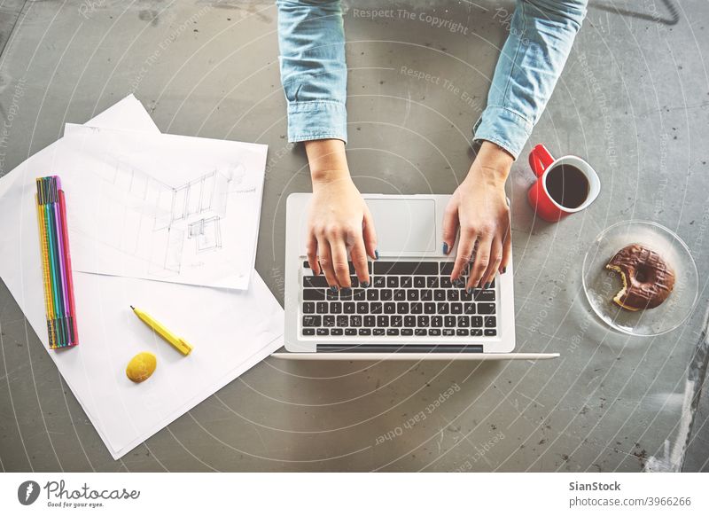 Top view of architect woman working at computer in office laptop business workplace hands breakfast keyboard desk table technology notebook coffee up writing