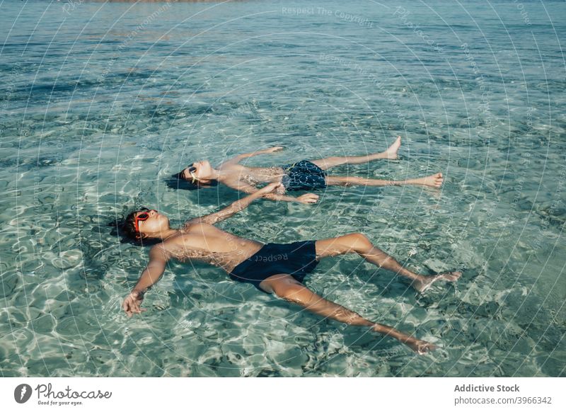 Two boys relaxed on the beach in summer child resting sea water aqua beach kids blue caucasian childhood enjoy european goggles happiness happy little ocean