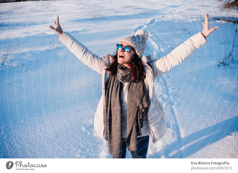 happy young woman hiking in snowy mountain wearing modern coat at sunset. winter season. nature cold caucasian forest wanderlust travel walk hiker mood