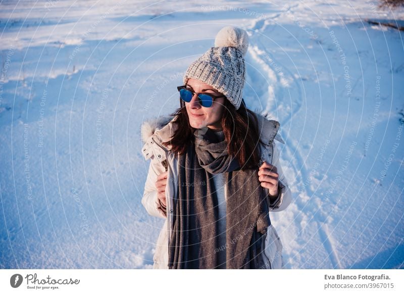 happy young woman hiking in snowy mountain wearing modern coat at sunset. winter season. nature cold caucasian forest wanderlust travel walk hiker mood