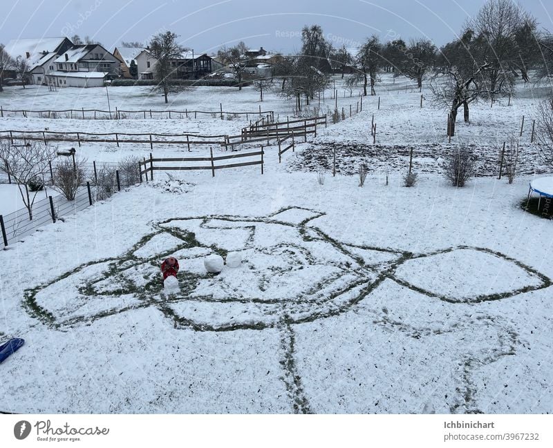 Child painting shapes in the snow in giant format snow child paints draws fantasy shape white imprints in snow Snow Winter White Joy Playing Exterior shot