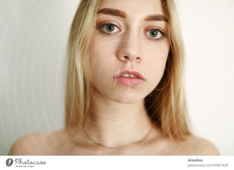 Portrait of a young long haired blonde woman in a bright room in front of a white wall Woman Girl Slim Blonde Long-haired portrait pretty Graceful Wild