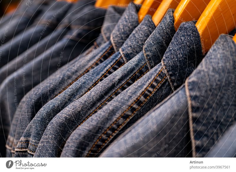 Selective focus on jacket jeans hanging on rack in clothes shop. Denim jeans with jeans pattern. Textile industry. Jeans fashion and shopping concept. Clothing concept. Denim jacket on rack for sale.