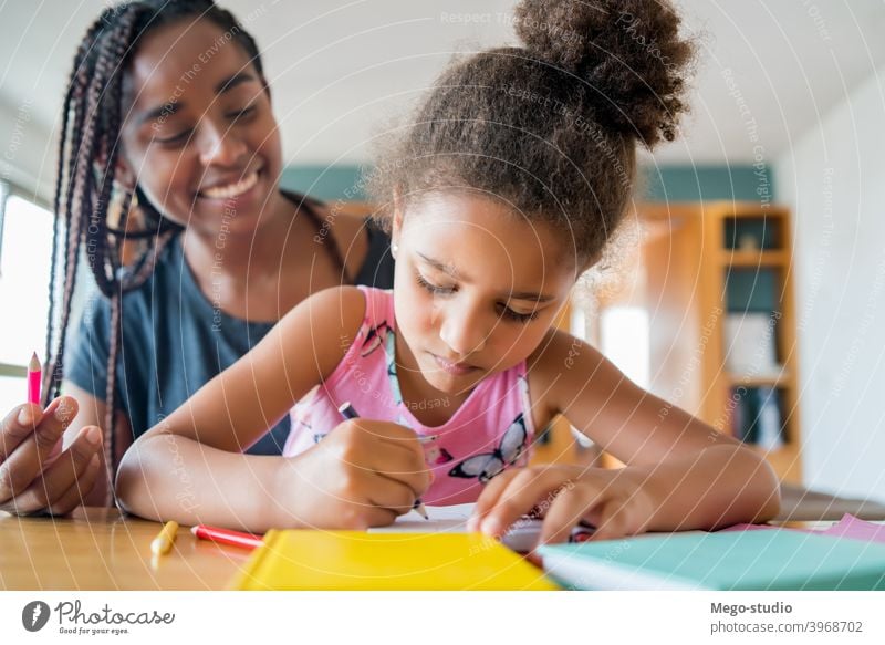 A father helping her daughter with homeschool. mother homework student learning lifestyle quarantine family children people lock down indoor motherhood