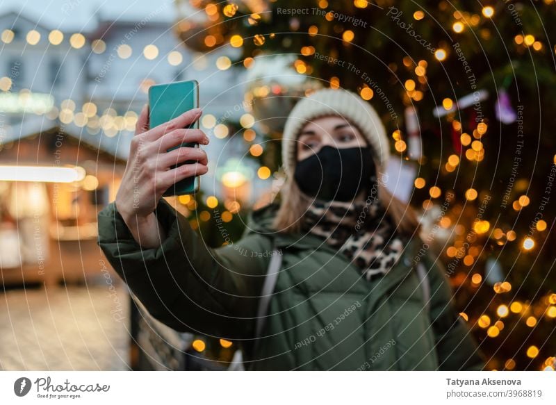 Woman in face mask taking selfie woman christmas market protection lifestyle photographing holiday coronavirus celebration winter tallinn estonia city season