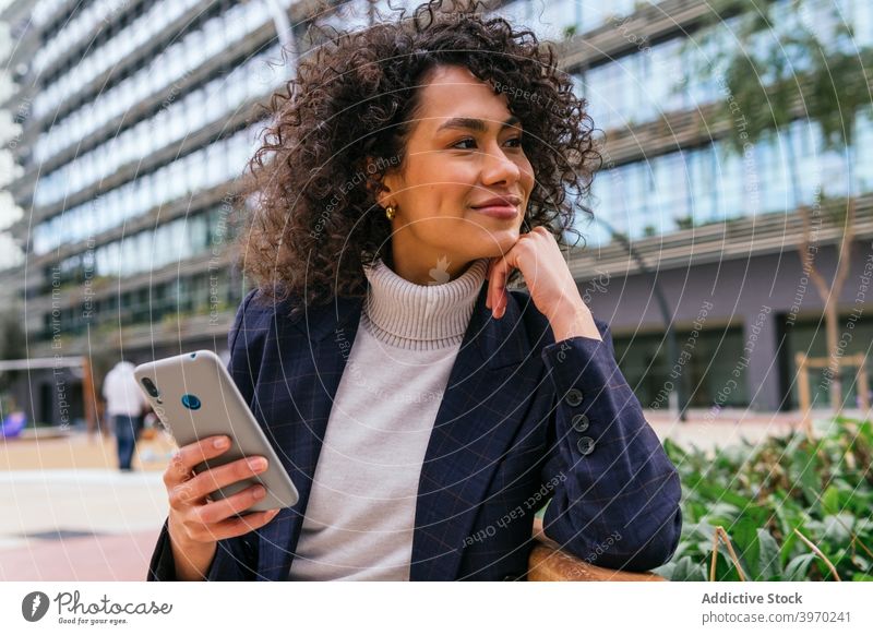 Happy businesswoman on smartphone on street speak mobile phone confident smile young ethnic female entrepreneur elegant urban lifestyle device gadget