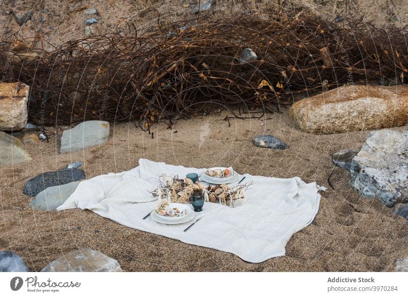 Picnic set on blanket on sandy beach picnic romantic food decoration seashore nature white summer coast vacation holiday relax recreation celebrate couple rest