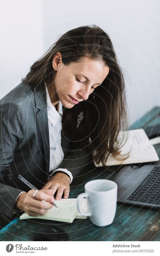 Businesswoman making notes during workday at home businesswoman take note write remote freelance busy plan formal workplace entrepreneur young job lifestyle