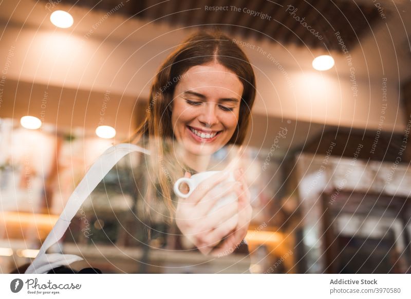 Happy woman with cup of coffee resting in cafe caffeine drink enjoy window young cheerful chill break positive female cozy lifestyle beverage hot drink smile