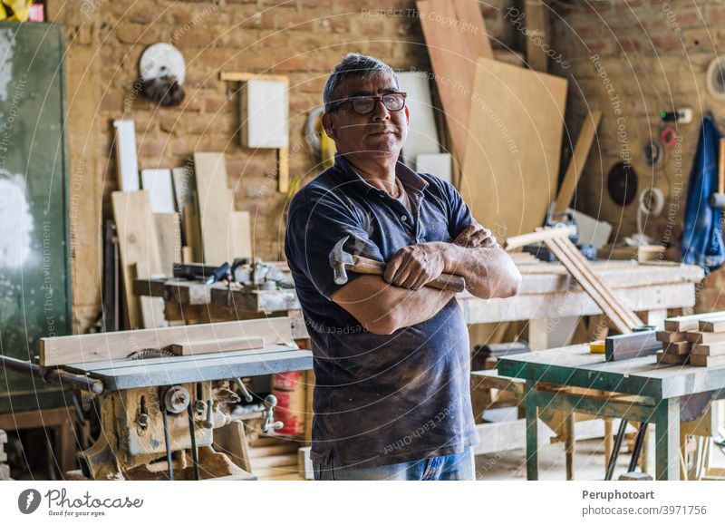 Portrait of senior carpenter in his workshop and looking at camera. carpentry craftsman male occupation people portrait working industry old plank standing