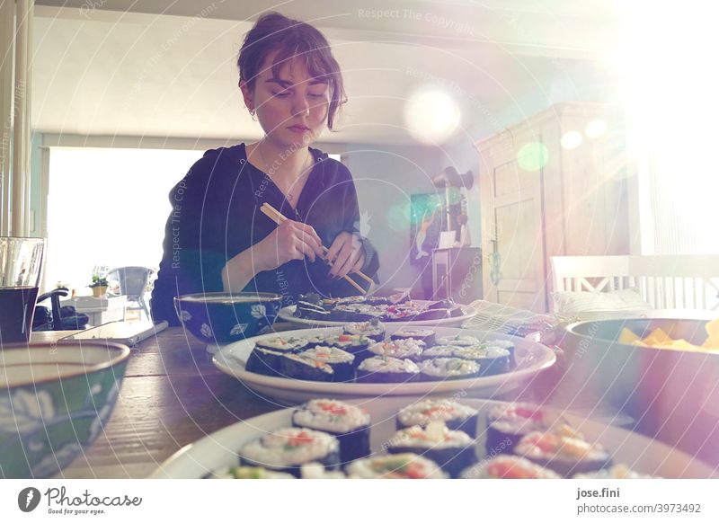 Young woman sitting with chopsticks at a table with sushi. Woman young adult teenager Student Lifestyle person Sushi Self-made Food Food Photography Vegetable