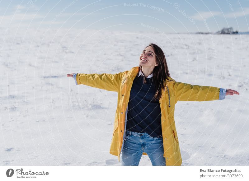 happy woman hiking outdoors in snowy mountain. Nature and lifestyle yellow coat caucasian travel wanderlust backpack time out wellness liberty arm nature sun