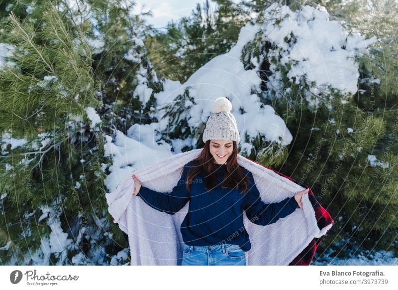 happy woman hiking outdoors in snowy mountain. Wrapped in plaid blanket. Nature and lifestyle wrapped relax caucasian sunny enjoy travel wanderlust backpack