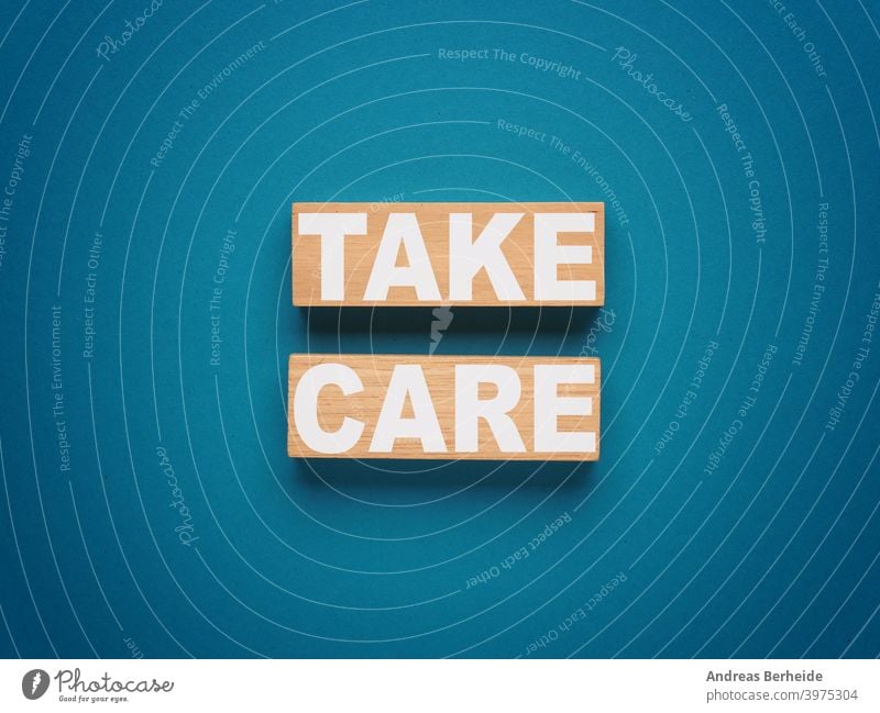 Two wooden blocks with inscription TAKE CARE on a blue background motivation self care healthy living good prevention healtcare relaxation meditation symbol