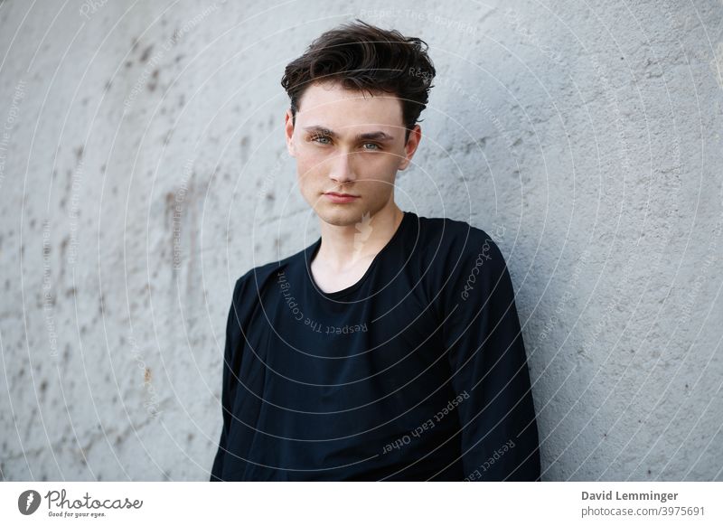 Young Handsome Male Model with James Dean Hair in front of a grey wall Portrait photograph portrait male young Young man Man teenager blue eyes green eyes