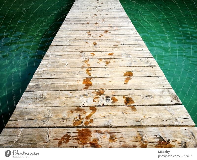 Boat jetty or bathing jetty made of beautiful old wood in the summer sunshine at the Alpsee in Schwangau near Füssen in the Allgäu in the Free State of Bavaria