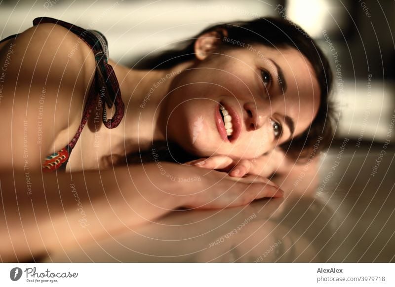 Portrait of a young woman lying with her head and arm on the table, play of light and shadow Woman naturally pretty Brunette Long-haired long hairs Slim