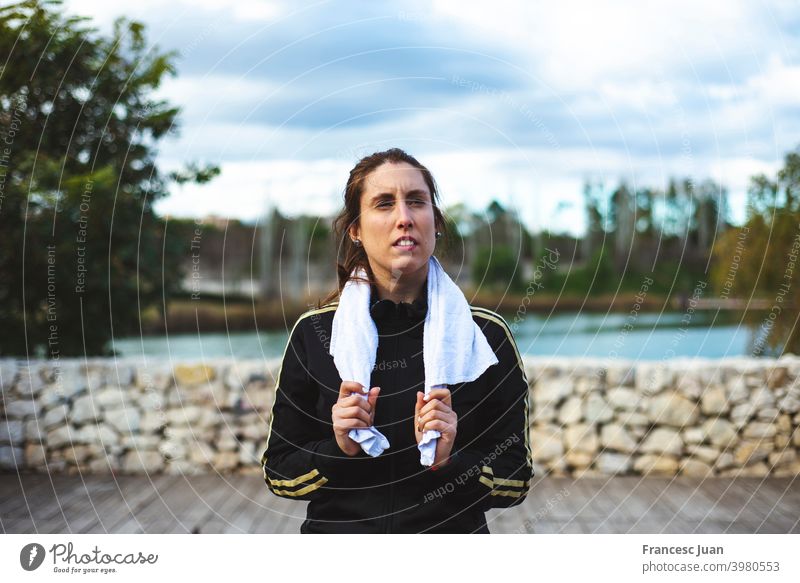 Tired sporty woman with towel relaxing after hard workout at park. fit girl health lifestyle training video wellness aerobics alone balance body class coach