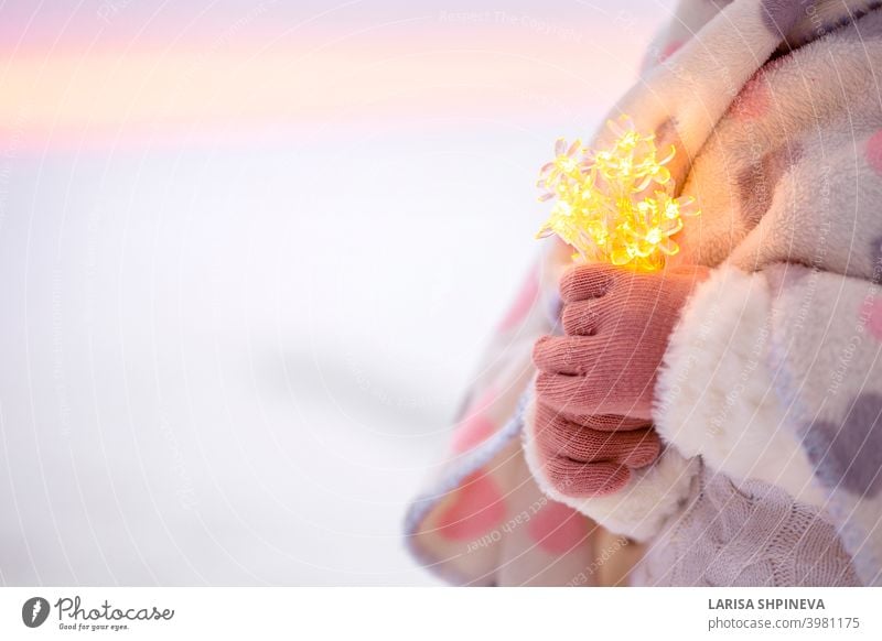 Little girl hands holding string of bokeh lights. Christmas decoration to make wish. bright christmas party background holiday celebration new happy shiny